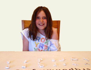 girl creating letters with clay